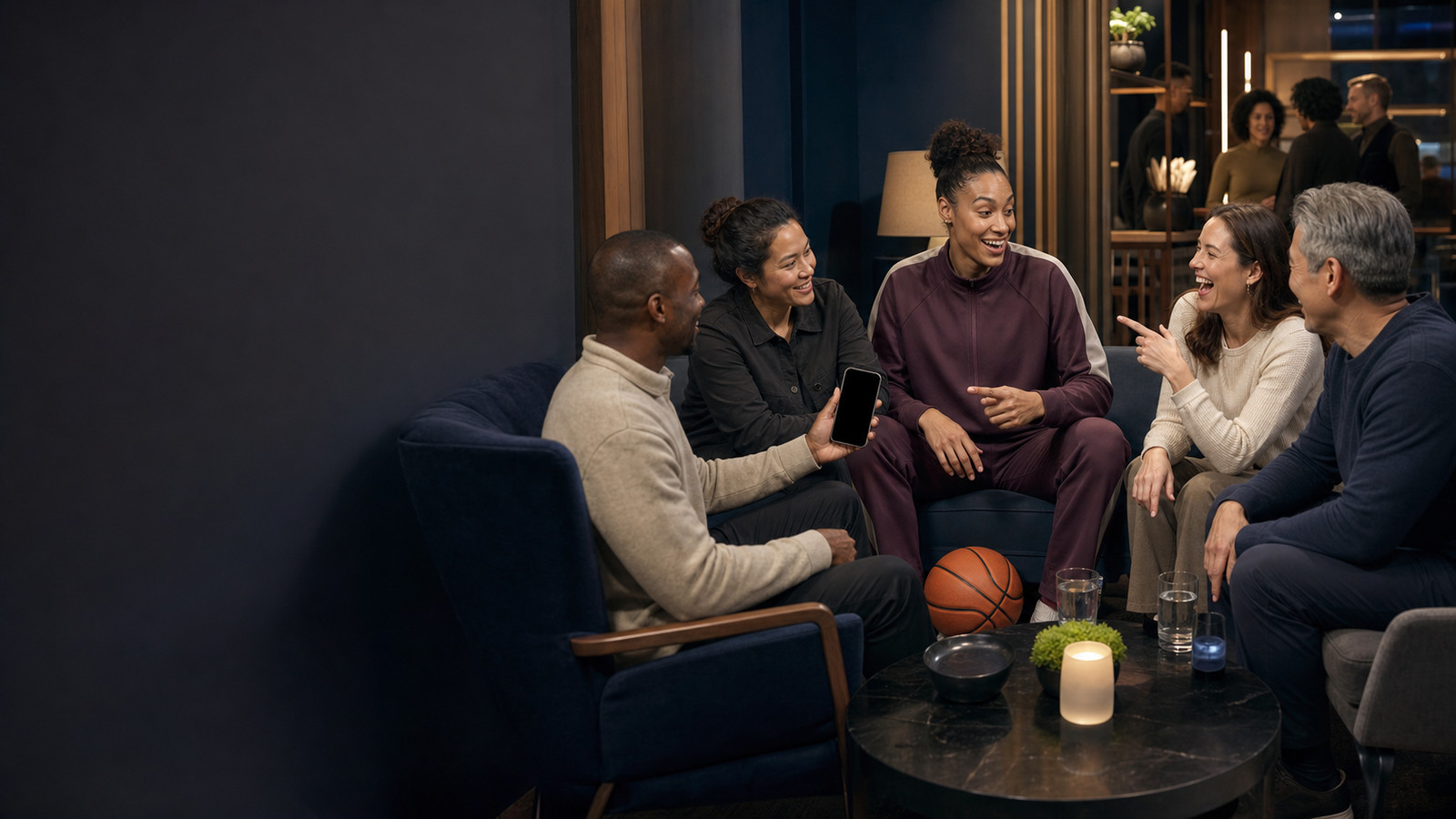 A group talking in warm lamplight, a basketball on the low table between them.